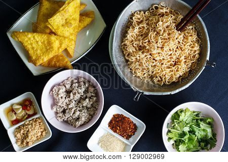 Ingredient spicy instant noodle with minced pork on wood background Top view