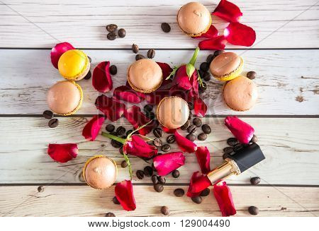Natural french macaruns and red roses pentals on flat with lipstick