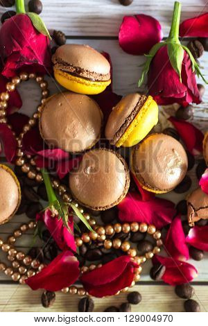 Macaruns with roses, necklace and coffee on flat