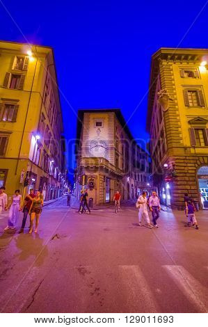 FLORENCE, ITALY - JUNE 12, 2015: People walking late at night on summer in Florence, lights on purple tone.