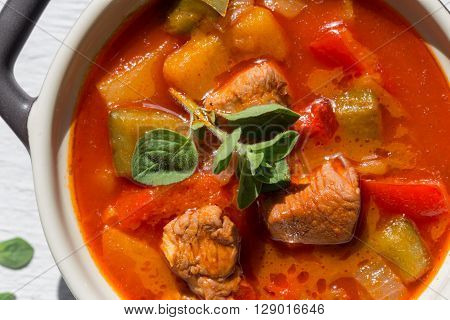 Goulash In A Black Cocotte With Marjoram On White Wood