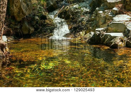 Small waterfall on the mountain river on a sunny morning not far from the waterfall Kalidonia Troodos Cyprus.