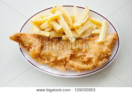 Traditional english meal - deep fried fish cod with chips served in local restaurant in Hastings England.