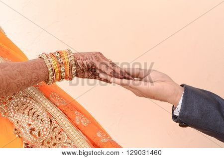 bride and groom joining hands during an Indian wedding ritual