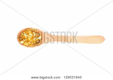 Fish Oil Capsules In A Wood Spoon On White Background