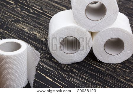 Rolls of toilet paper on wooden board