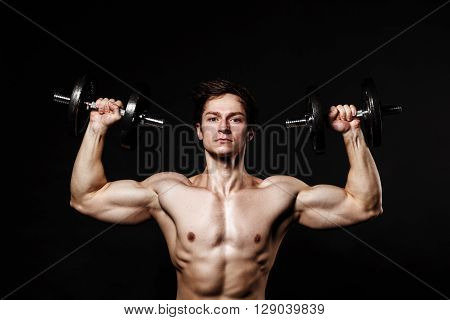 Handsome Athletic Man With Dumbbells Confidently Looking Forward. Strong Bodybuilder With Six Pack,