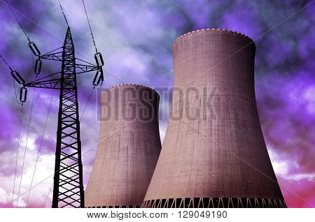 Nuclear power plant with electricity pylon against storm clouds
