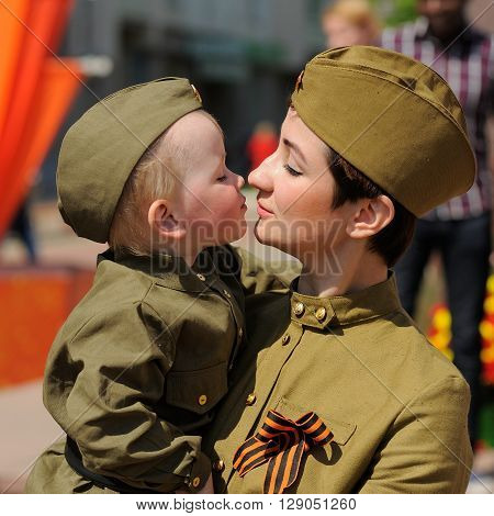 Orel Russia - May 9 2016: Celebration of 71th anniversary of the Victory Day (WWII). Woman with child in soviet military uniform with St.George ribbon closeup