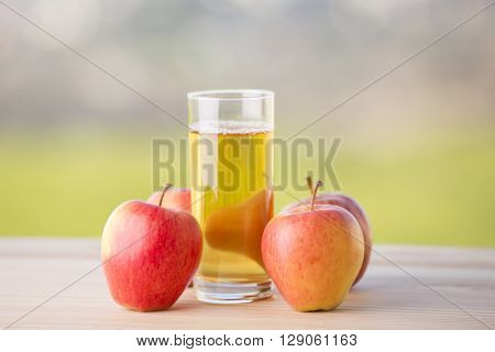 apples and apple juice on a wooden table, outdoor