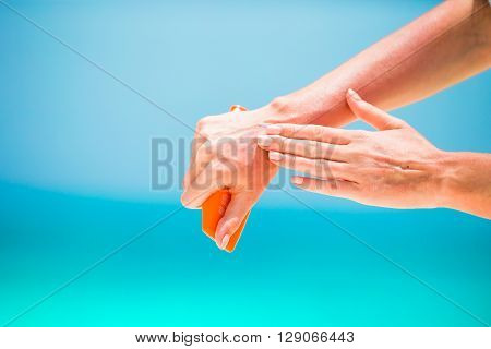 Woman hands putting sunscreen from a suncream bottle background the sea