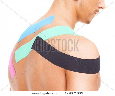 Muscular man with kinesiotaping on the shoulder, isolated on white background