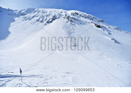 Blue competition flag blown by the wind on a mountain in winter and skier in background
** Note: Soft Focus at 100%, best at smaller sizes