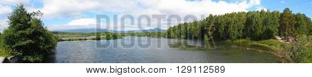 Lake in a mixed forest with a view of the mountain