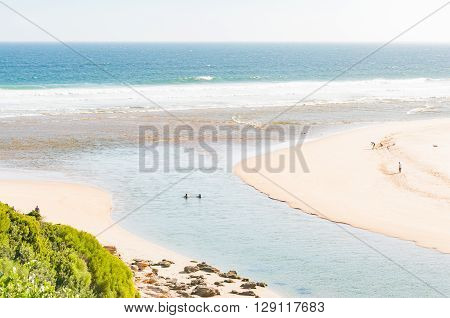 SEDGEFIELD SOUTH AFRICA - MARCH 4 2016: Holidaymakers at the mouth of the Swartvlei (Black Lake) the largest of the lakes in the Wilderness Lake Area