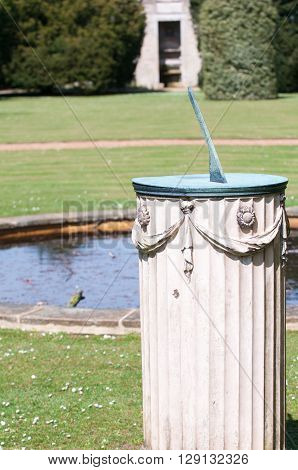 Sundial in the grounds of a garden in bright sunlight