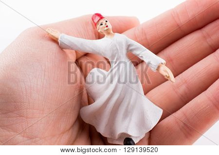 Hand holding a Sufi Derviş on a white background