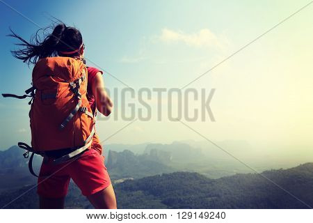successful woman hiker enjoy the view on mountain top
