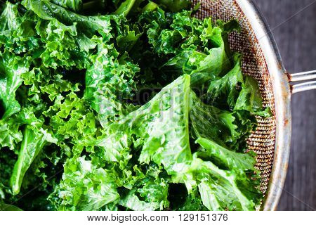 Chopped kale in a colander. Big close-up on green leaves of kale