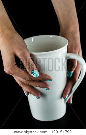 hands and beautiful nails on a black background with white large Cup