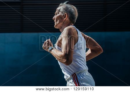 Ekaterinburg Russia - May 3 2016: elderly man athlete running on a city street during City marathon