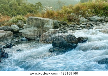 Beautiful Reshi River water flowing through stones and rocks at dawn Sikkim India. Reshi is one of the most famous rivers of Sikkim flowing through the state and serving water to many local people.