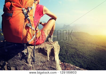 silhouette of young successful woman hiker on mountain peak