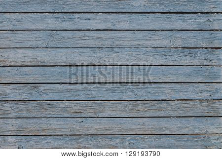 Wooden background with peeling blue paint horizontal boards