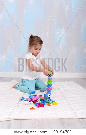 Child girl playing with toys constructor. vertical photo