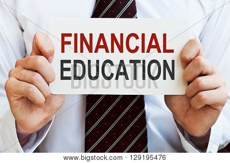Financial Education. Businessman holding a card with a message text written on it