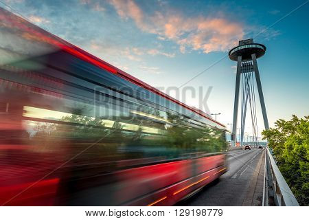 View on the Modern bridge with observation deck and restaurant called UFO in Bratislava city at the sunset. Long exposure technique with motion of cars