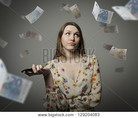 Young woman and falling Euro banknotes. Consumerism concept.