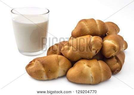 Pile of fresh bavarian pastries rolls with glass of yogurt, kifla kiflice, isolated on white background