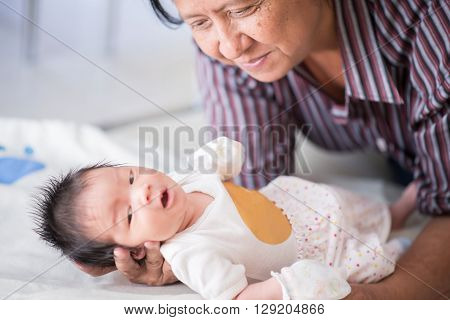 Cute asian baby newborn looking at grandmom