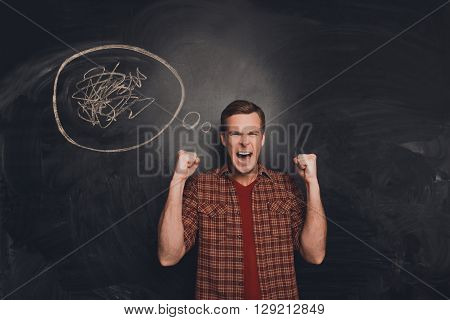 Depressed Overworked Young Man Screaming With Raised Fists
