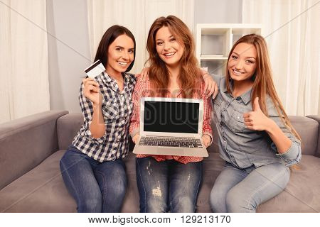 Cheerful Girls Showing Laptop, Bank Card And Showing Thumb Up