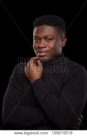 Dangerous robber or burgler smiling for camera while staying in prison over black background. Black-skinned man in balaclava in studio. Isolated on black.