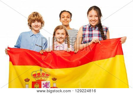 Group of four happy multiethnic teenage kids with flag of Spain, isolated on white