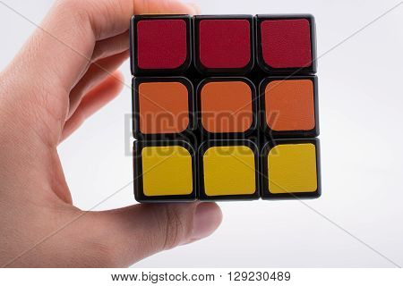 hand holding Rubik's cube on white background