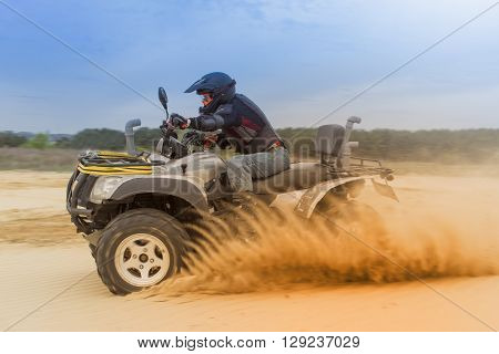Racing ATV in the sand in the summer on the prepared track.