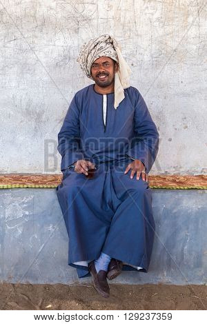 DARAW, EGYPT - FEBRUARY 6, 2016: Local camel salesman holding glass.