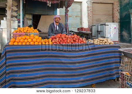 DARAW, EGYPT - FEBRUARY 6, 2016: Local food vendor at Daraw market selling oranges and tomatoes.
