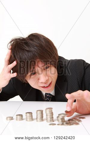 stack of coins collapsed when businessman put a coin