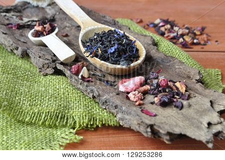 Tea in a wooden spoon,on the background of green textiles.