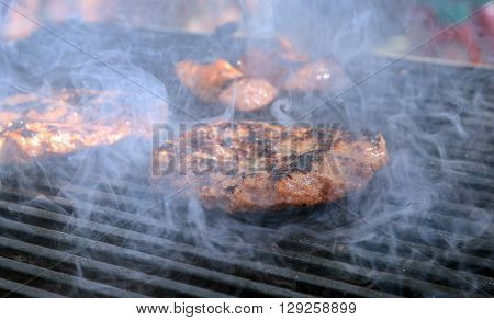 picture of a grilling burger on a coal grill