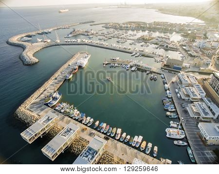 Aerial view of fishing boats docked at the Limassol old port (palio limani) in Cyprus next to the Marina part of the ports authority. A view of the harbor the mediterranean sea the water boat and fish nets and fishing equipment.
