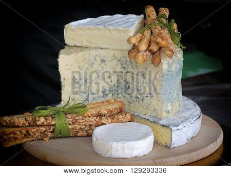 A large piece of cheese on a wooden Board