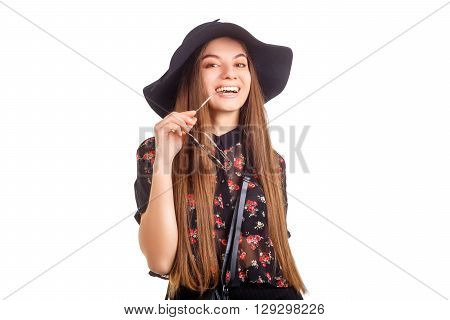 girl in hat smiling and posing in the studio, fashion concept
