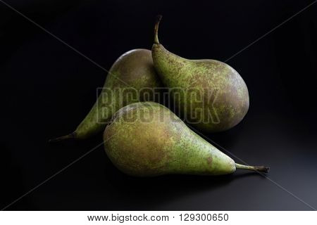 Three pears on black background