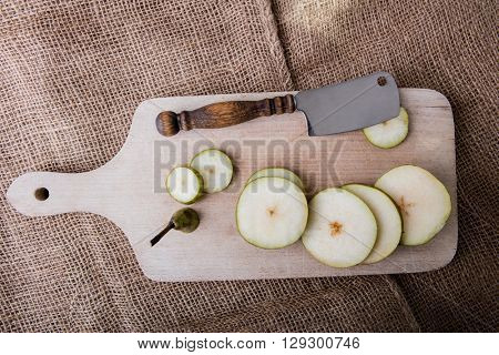 Sliced pear and chopper on the wooden cutting board